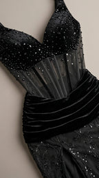 Close-up detail of sheer boned corset bodice and draped velvet waistline on black gown