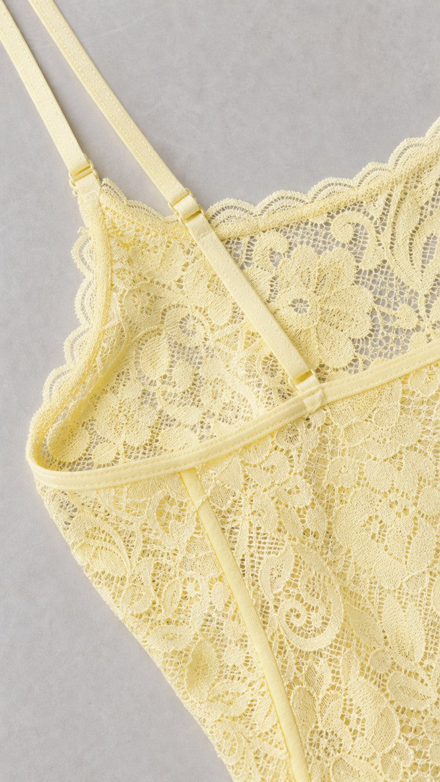 Close-up detail of yellow lace bodice showing adjustable straps and scalloped edge