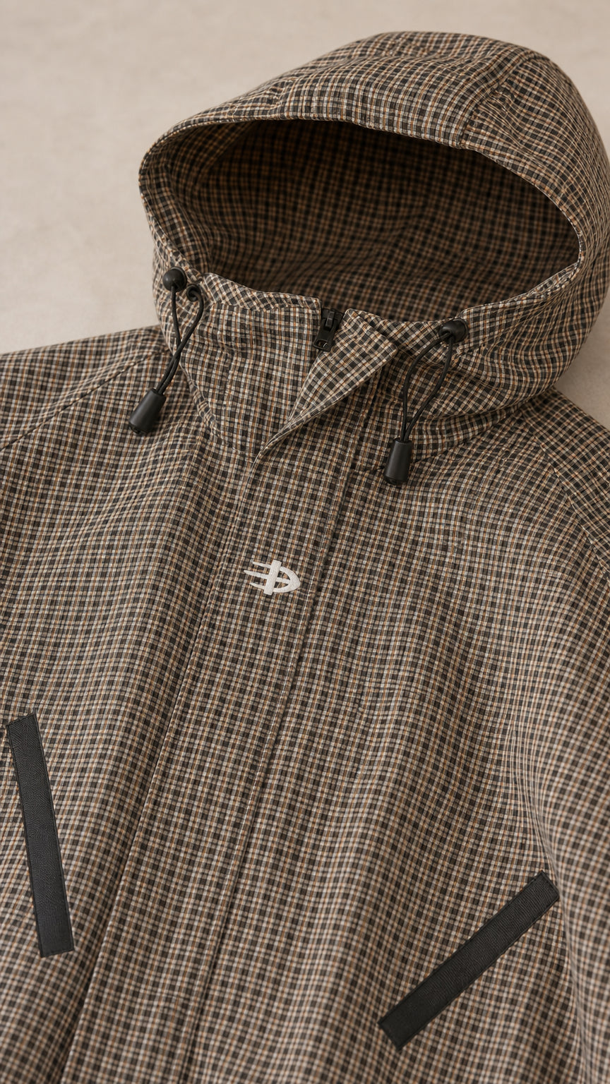Close-up detail of brown houndstooth hooded jacket with drawstring and chest logo