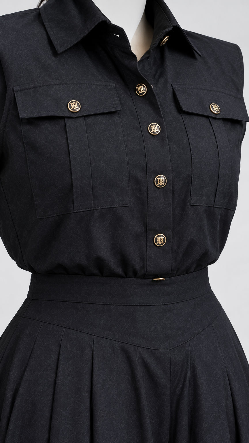 Close-up detail of black button-down utility blouse with chest pockets and pleated waist