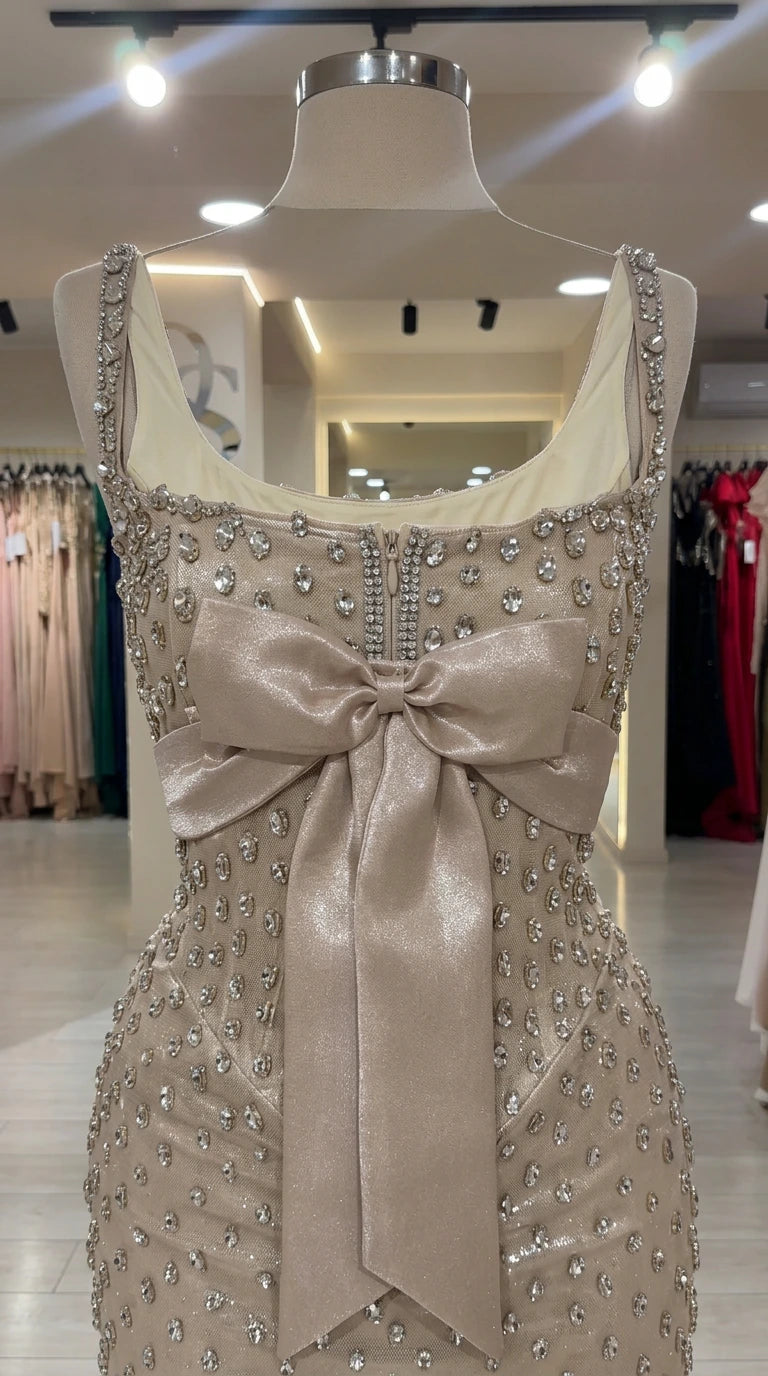 Close-up detail of champagne embellished bodice with wide straps and statement satin bow