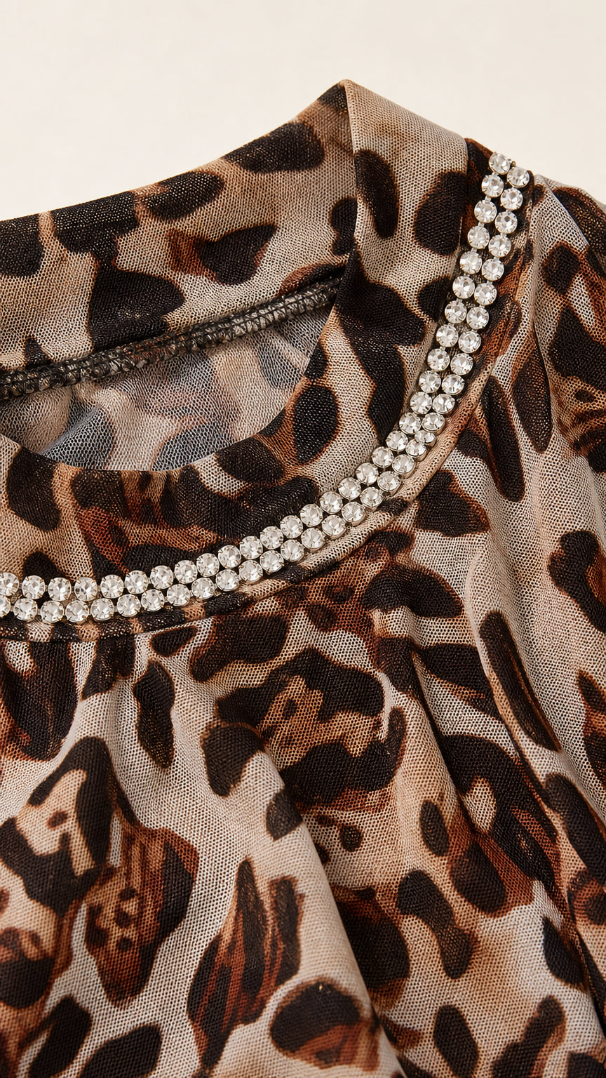 Close-up detail of sheer leopard fabric and sparkling double-row rhinestone mock neckline