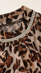 Close-up detail of sheer leopard fabric and sparkling double-row rhinestone mock neckline