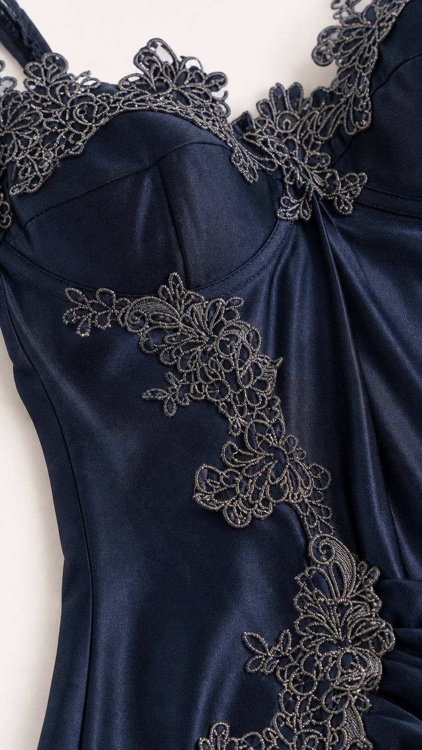 Close-up of navy blue satin bodice with intricate lace appliqué