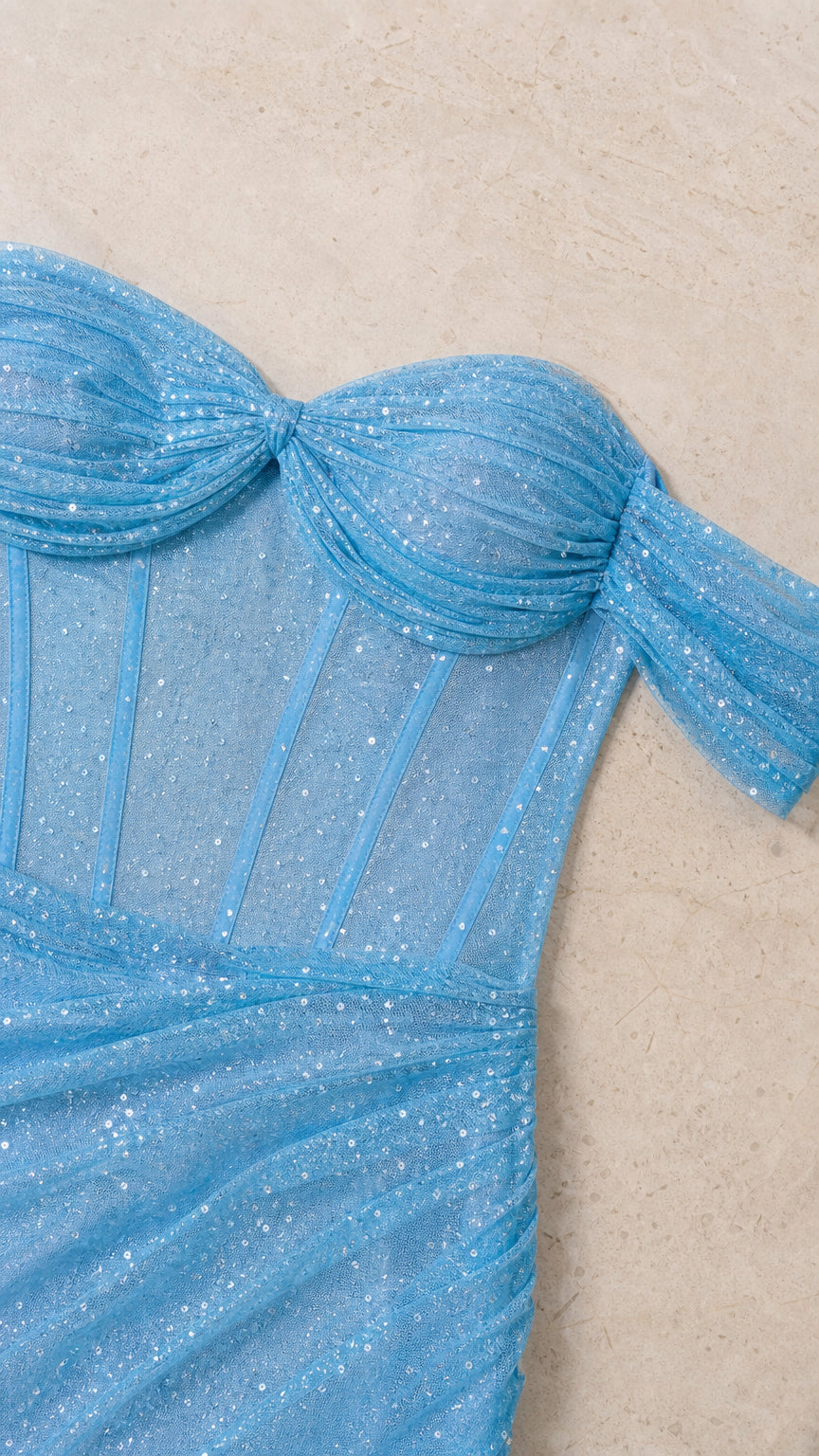 Close-up of structured boning and pleated bust on sky blue glitter dress