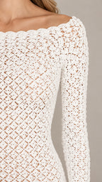 Close-up detail of white crochet openwork texture and scalloped neckline