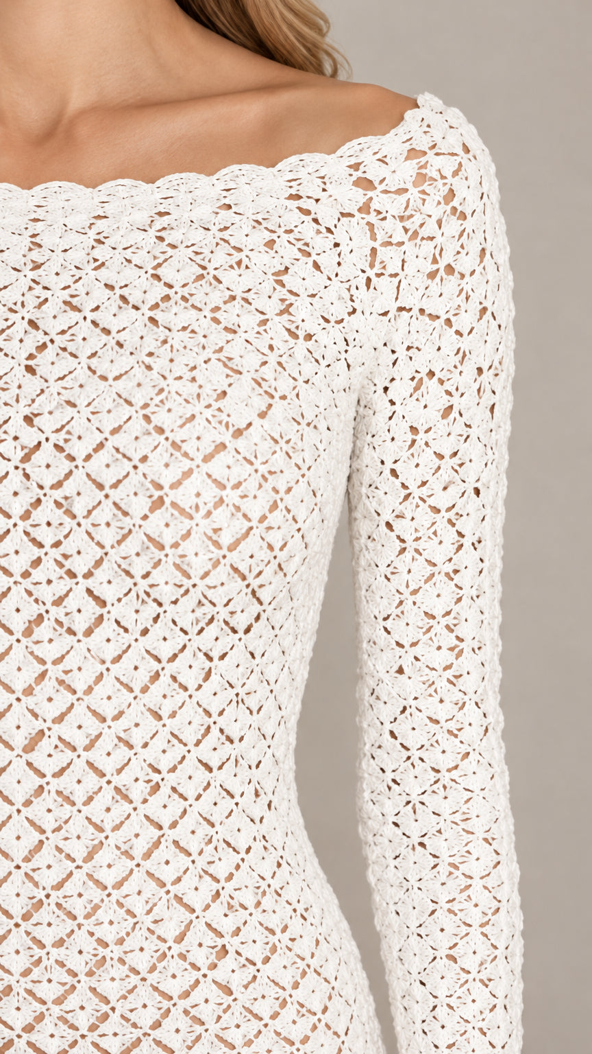 Close-up detail of white crochet openwork texture and scalloped neckline