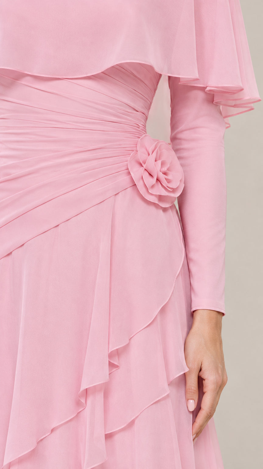 Close-up of ruched waist, 3D rosette floral accent, and chiffon ruffles on pink dress