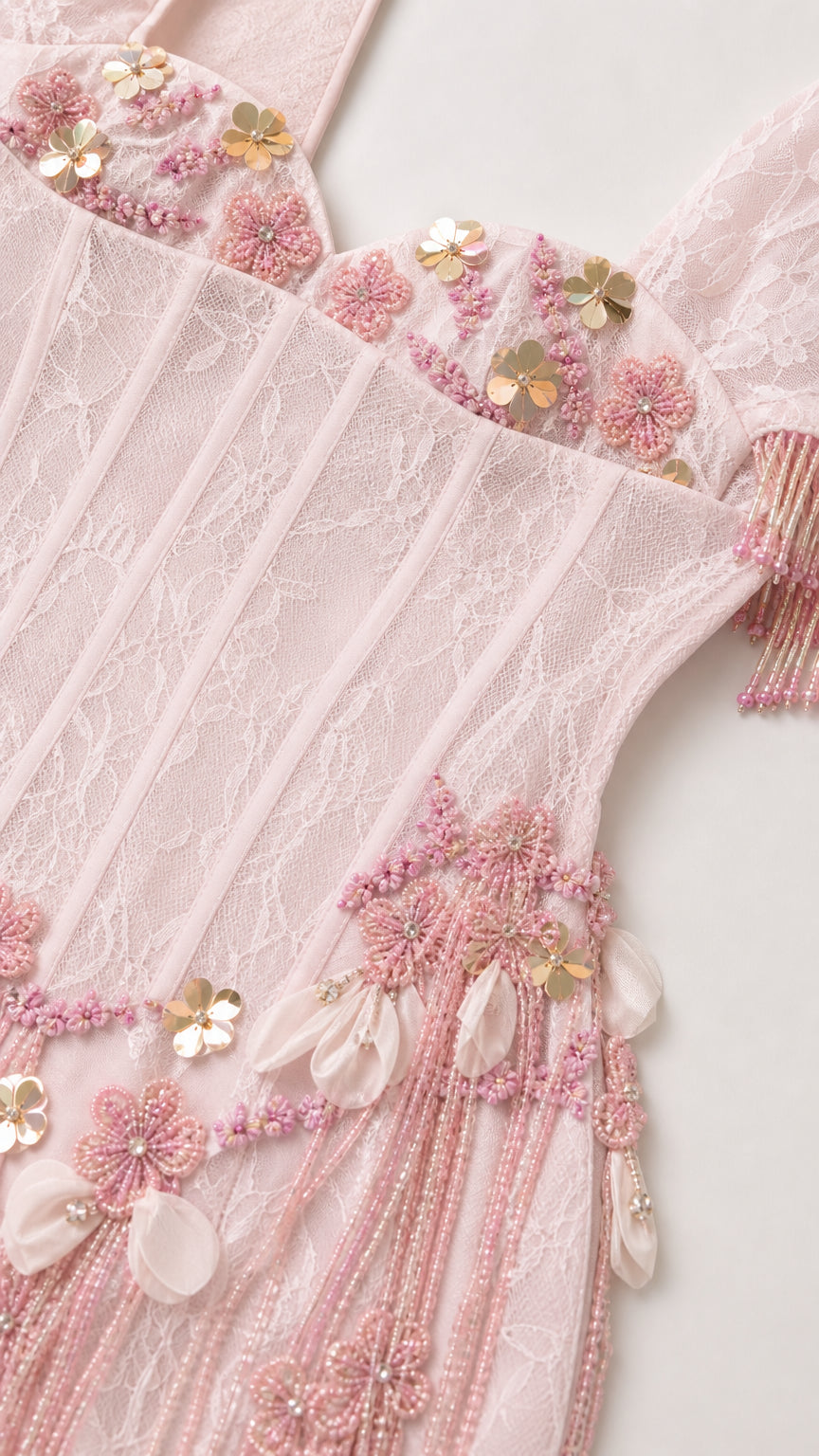 Close-up detail of 3D floral appliques, beadwork, lace, and fringe on corset bodice