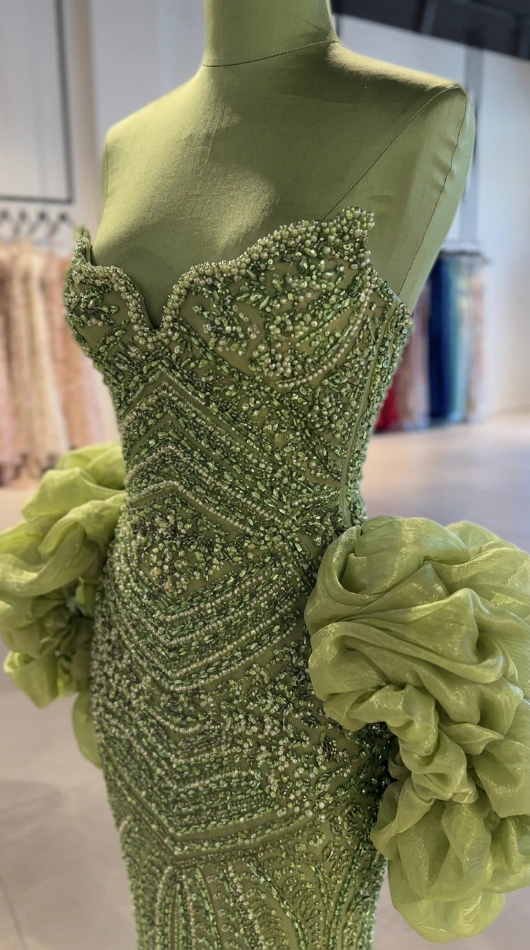 Close-up mannequin detail of green bodice showing intricate beadwork and sweetheart neckline