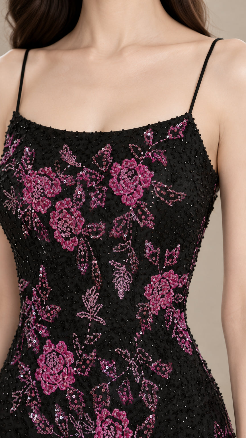 Close-up detail of magenta floral sequin embroidery on black evening gown