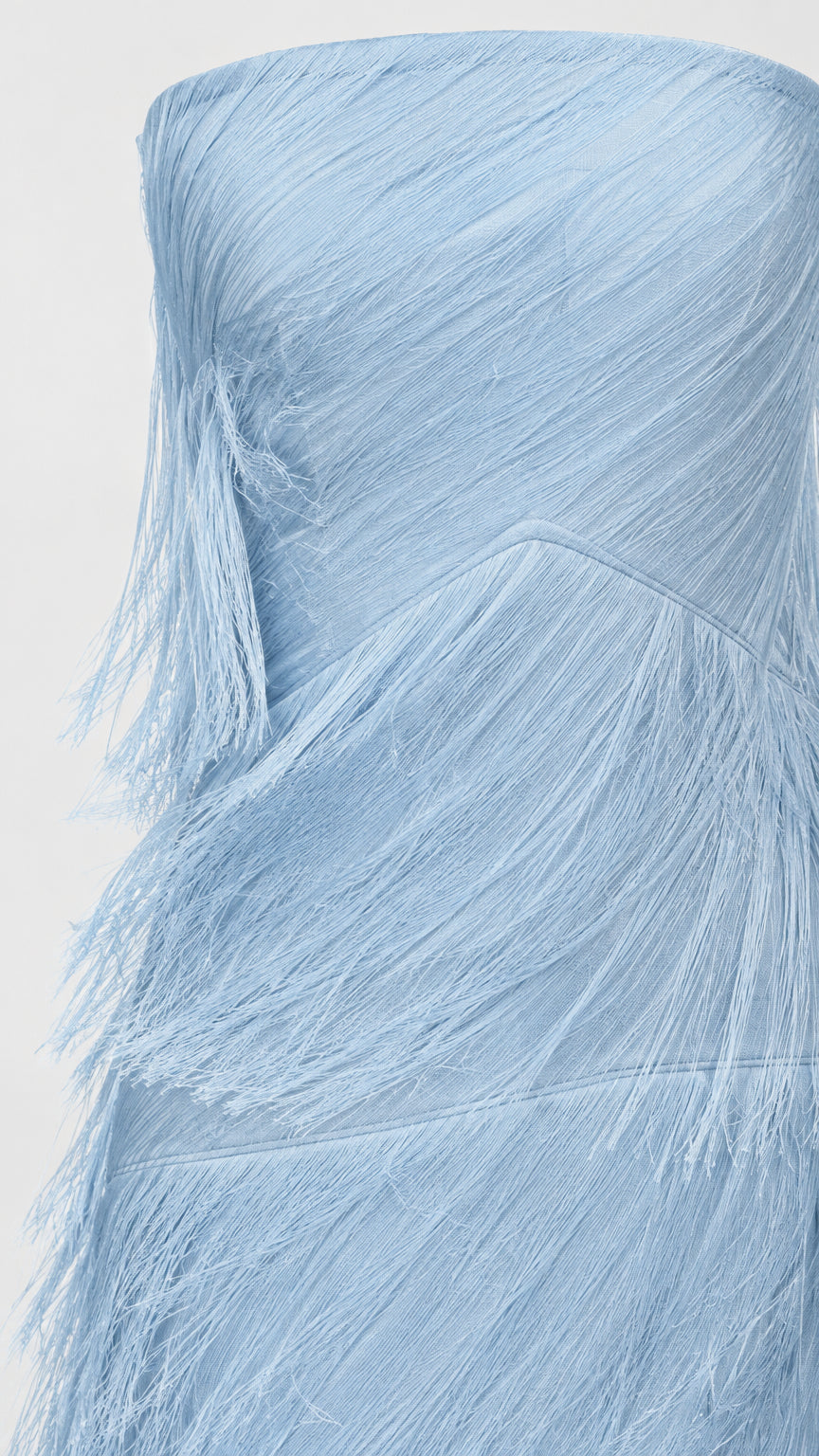 Close-up detail of textured diagonal fringe layers on sky blue strapless dress