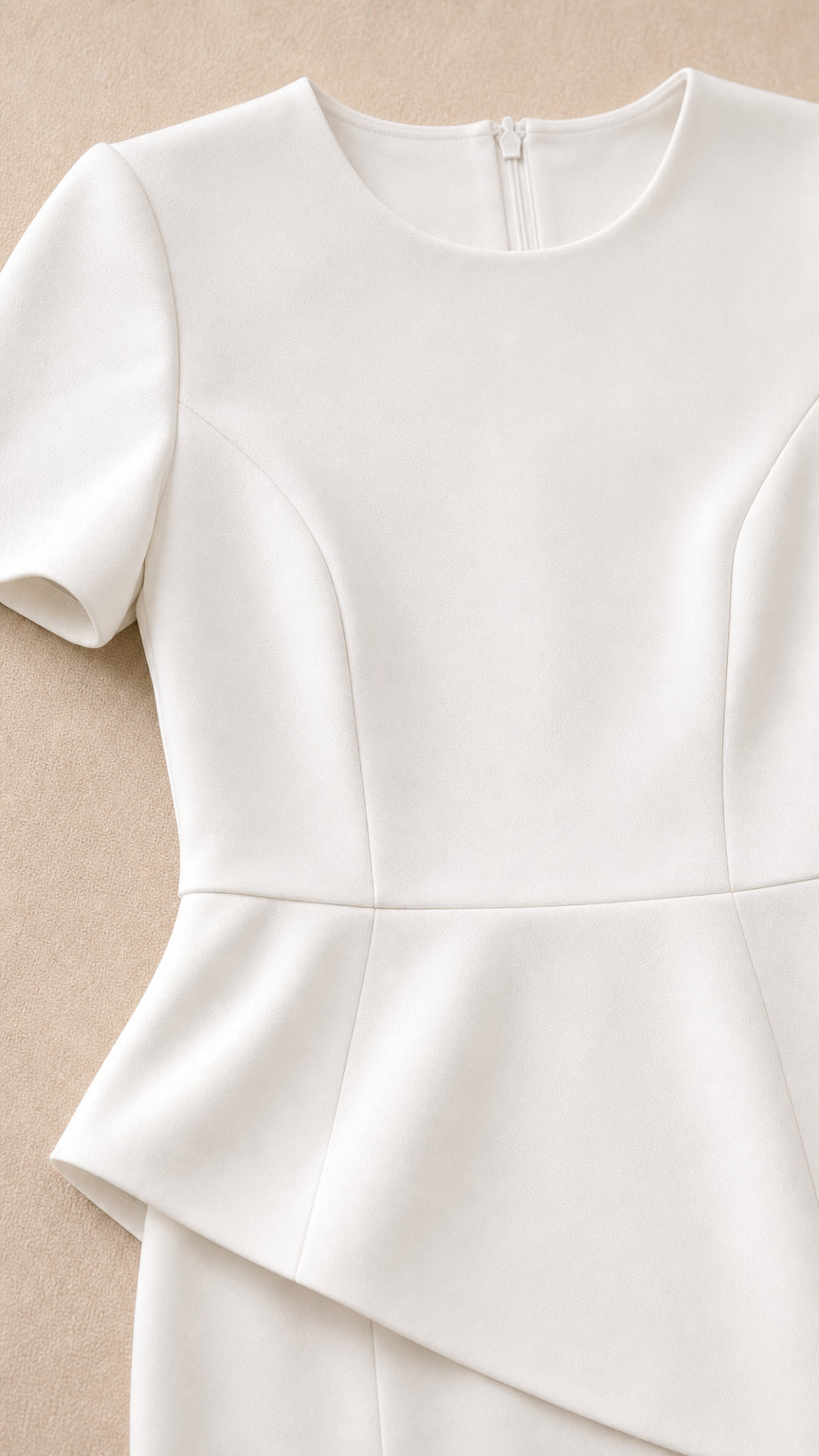 Close-up detail of white crew neckline, bodice tailoring, and asymmetrical peplum waist