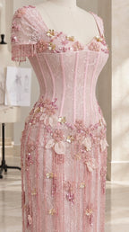 Close-up detail of pink corset bodice with 3D floral appliqués and beaded tassel sleeve