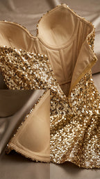 Close-up detail of structured corset bodice, internal boning, cups, and gold sequin fabric