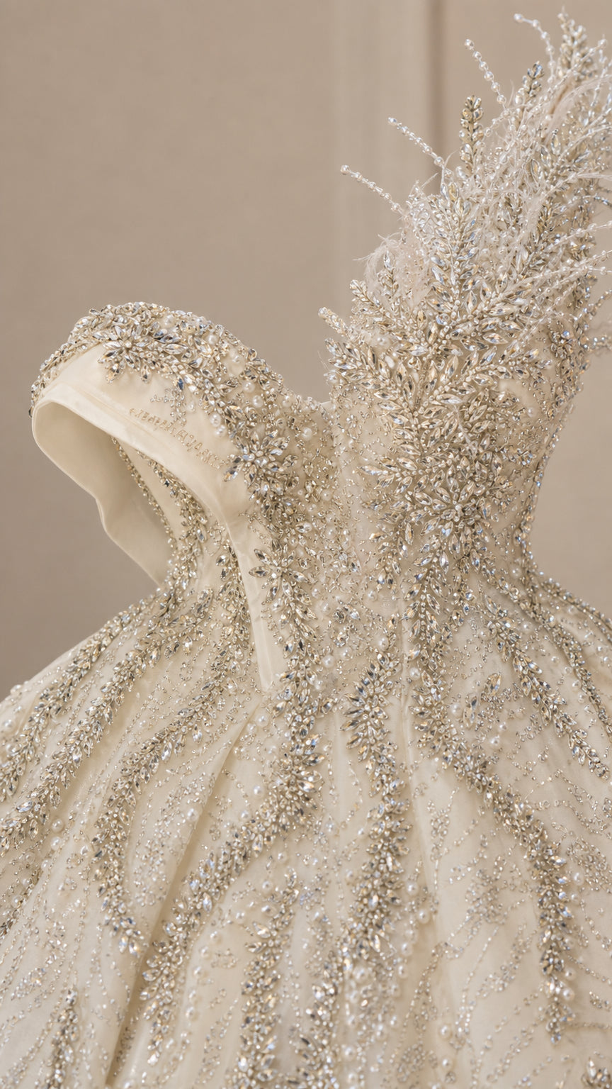 Close-up of champagne beaded bodice and sculpted feather shoulder detail