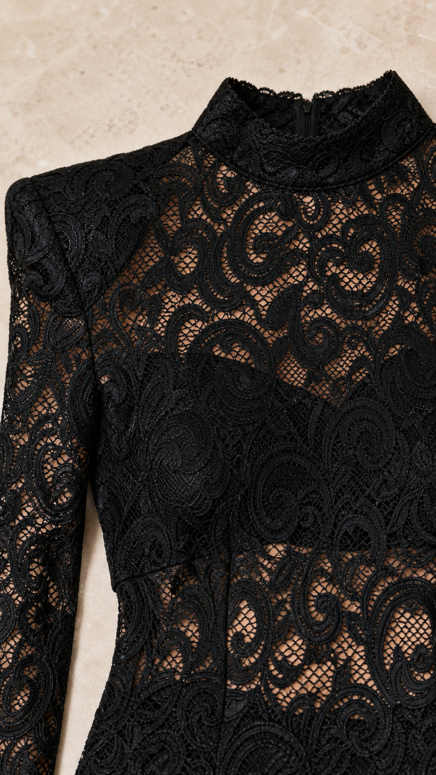 Close-up detail of black intricate floral lace texture and structured padded shoulder