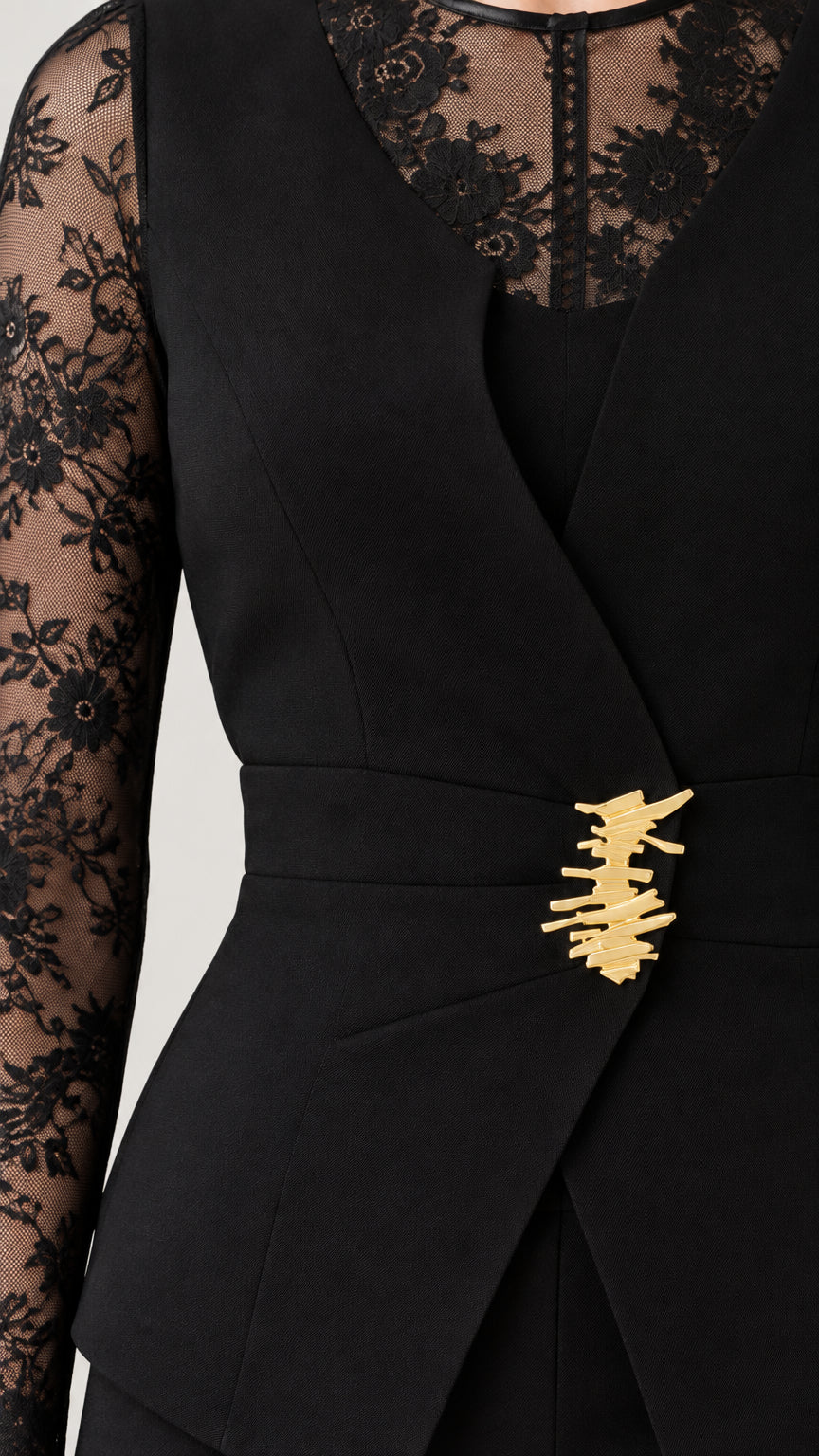 Close-up of black blazer top showing sheer floral lace neckline and gold-tone waist clasp