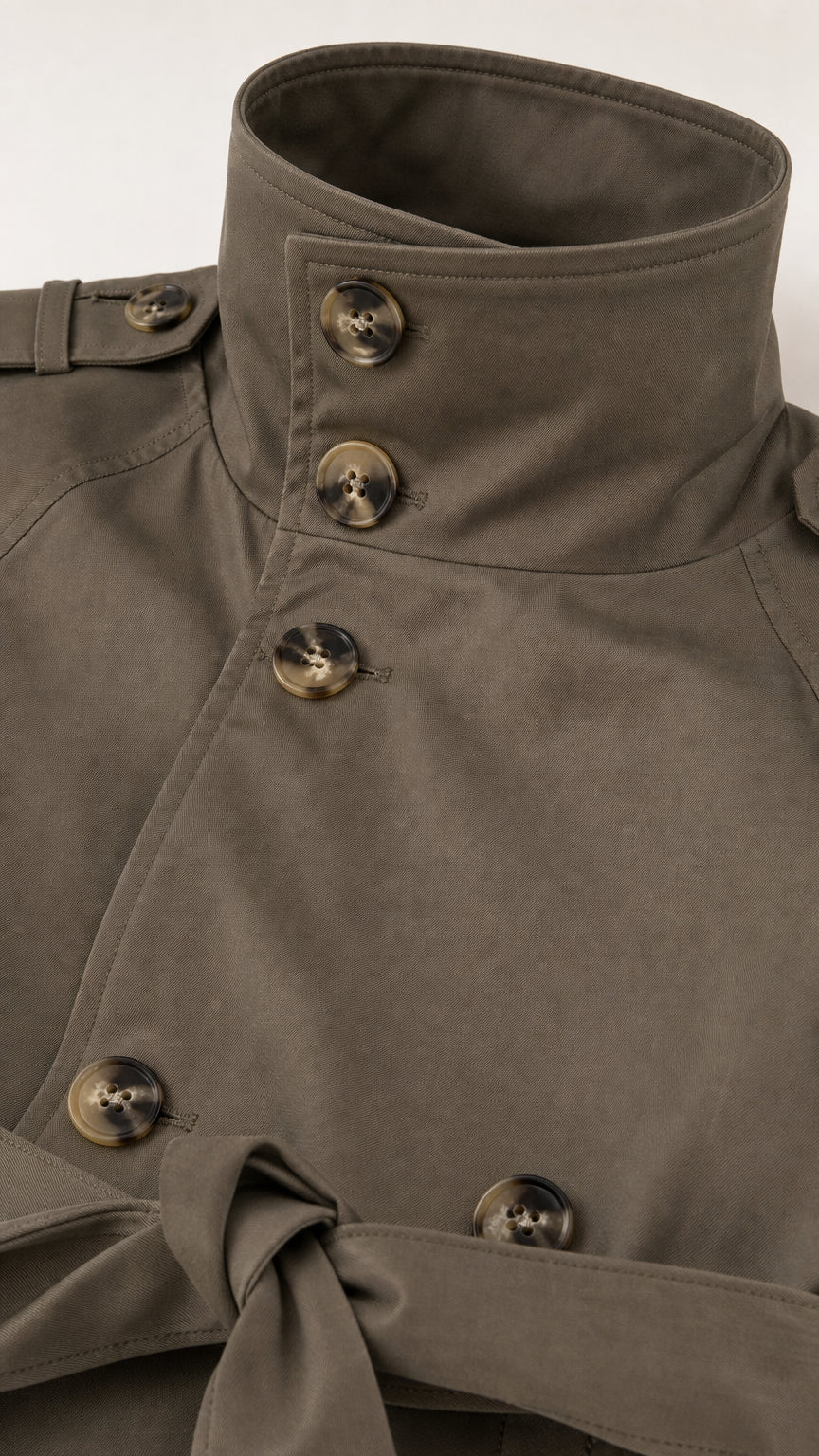 Close-up detail of high stand collar, tortoise buttons, and waist belt on Olive Green trench jacket