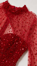 Close-up detail of beaded neckline and sequin embellishments on red sheer mesh
