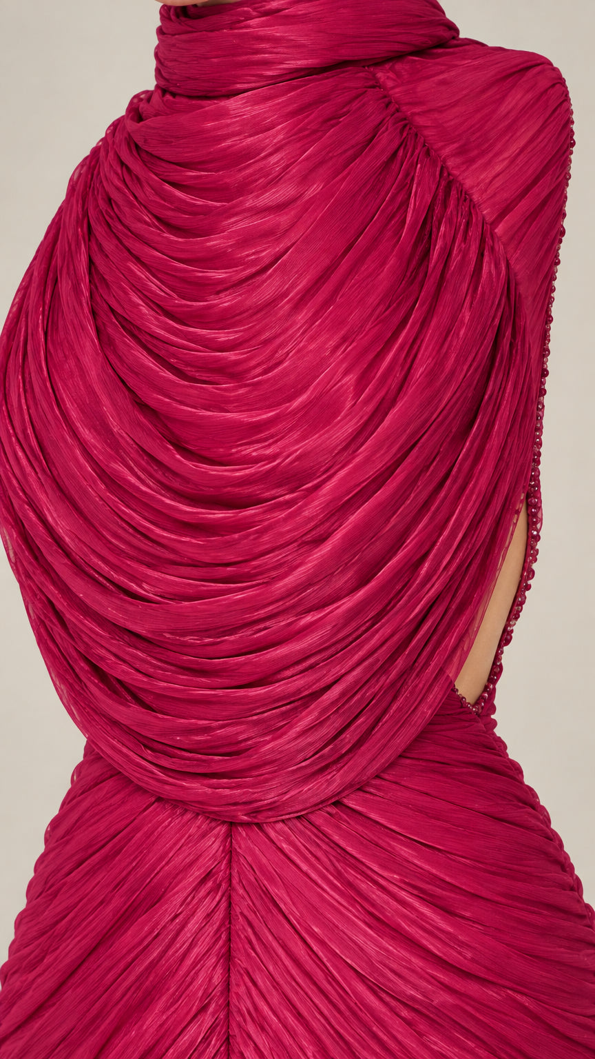 Close-up detail of textured ruching and draped neckline on magenta evening dress