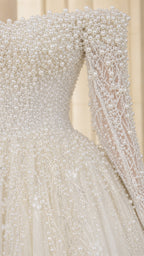 Close-up detail of dense faux pearl and crystal bead embellishments on sleeve and bodice