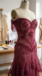 Close-up mannequin view showing intricate beadwork and fringe sleeves on burgundy bodice