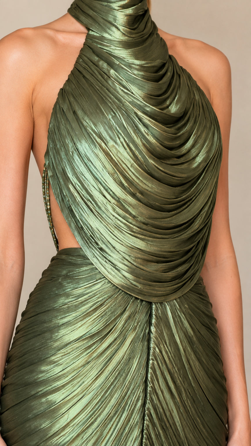 Close up view of draped cowl halter neckline and pleated fabric in olive green