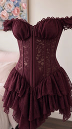 Close-up detail of burgundy lace corset bodice with visible boning and tiered ruffles