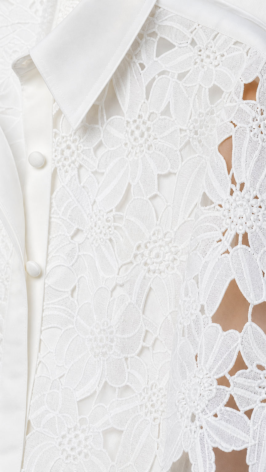 Close-up detail of white floral openwork lace texture and tailored collar button closure