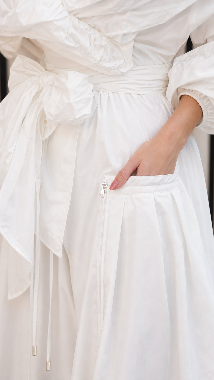 Close-up detail of pocket and tie belt on white maxi dress