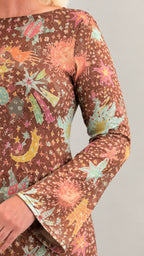 Close-up detail of celestial print pattern on sleeve and boat neck neckline in brown