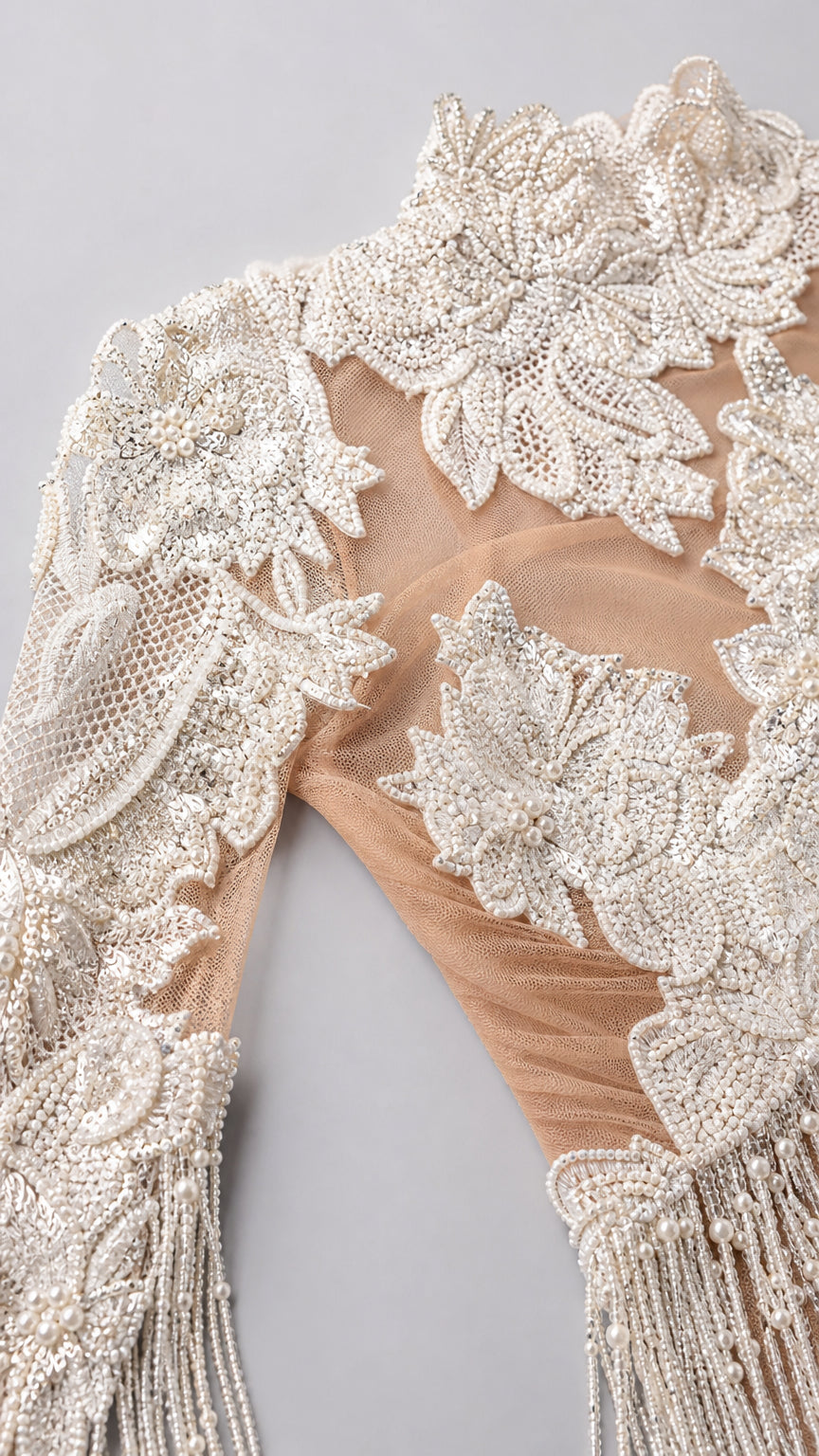 Close-up detail of embroidered floral lace and beadwork on sheer illusion mesh
