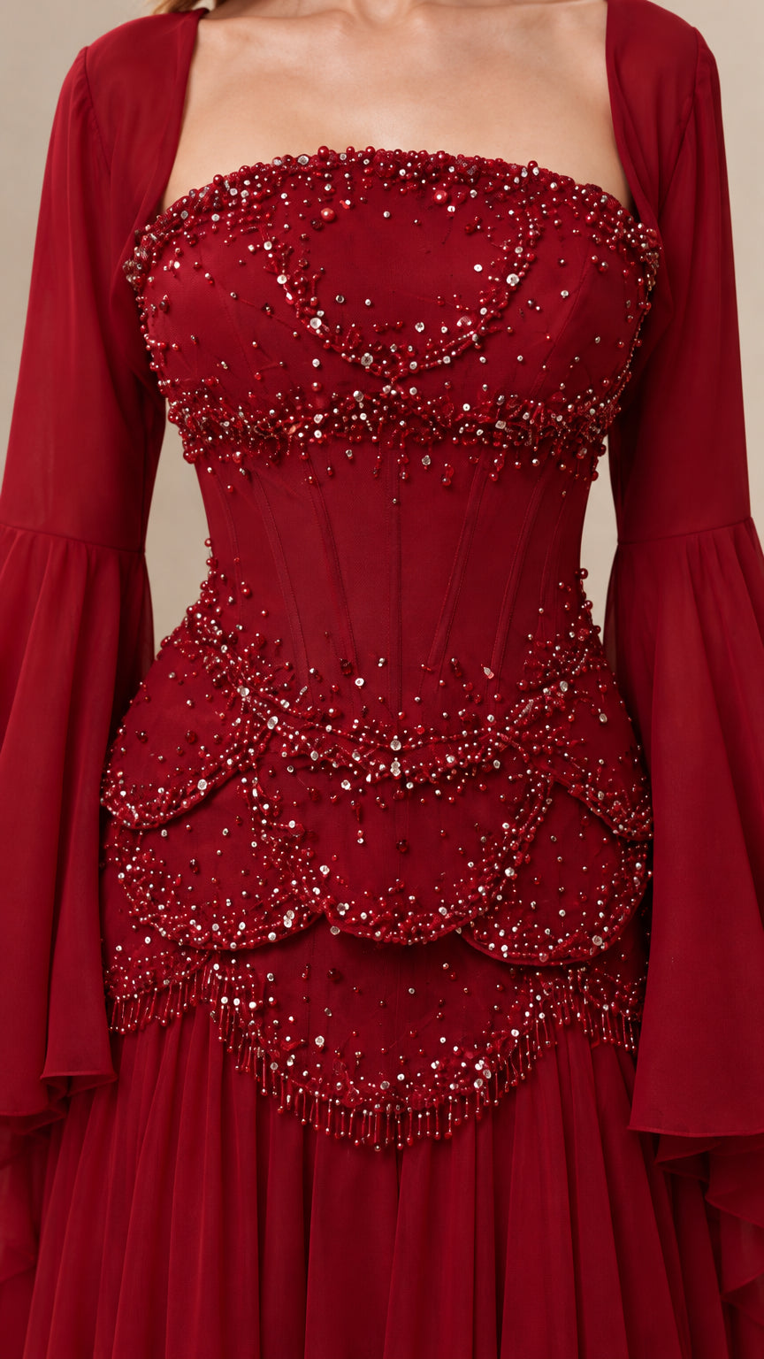 Close-up detail of intricate scalloped beading and corset-style bodice on burgundy evening gown