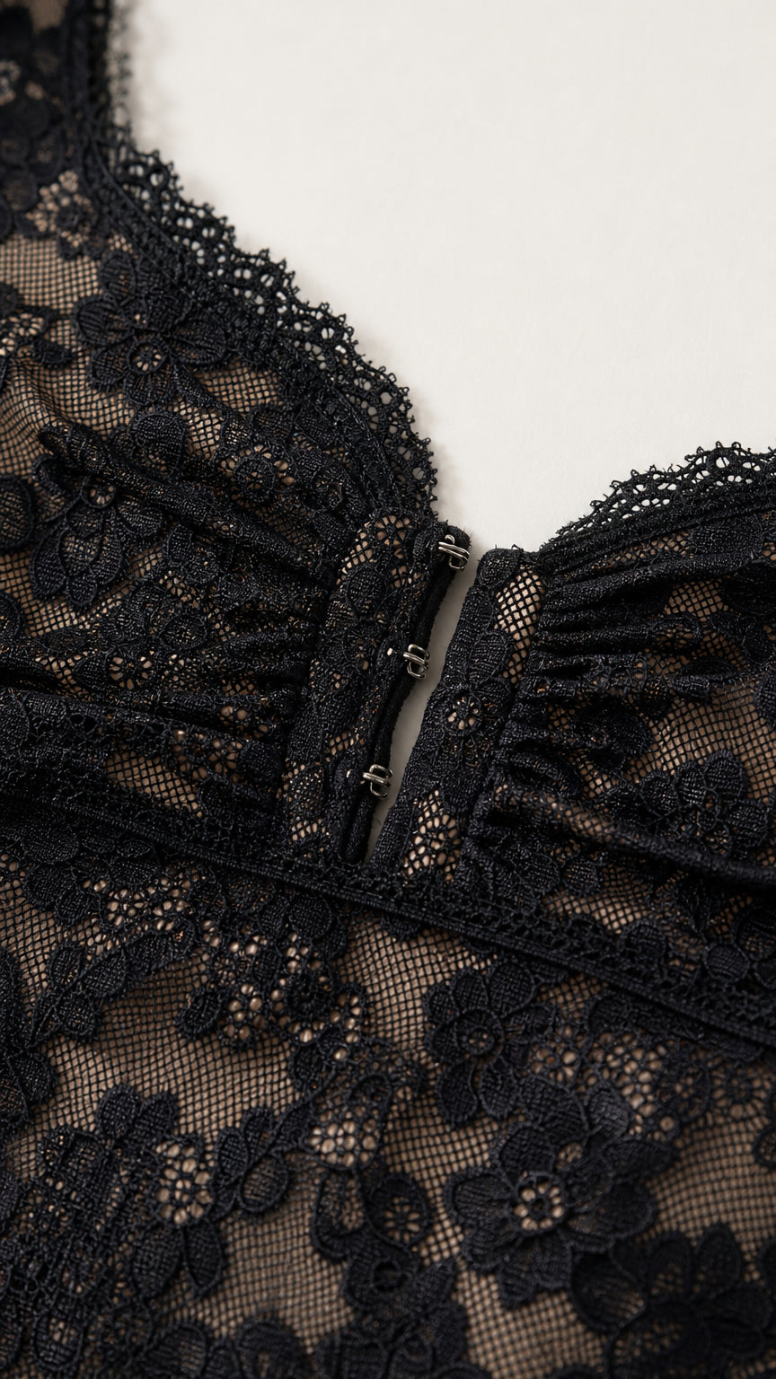 Close-up detail of sweetheart neckline and hook-and-eye closure on black lace dress