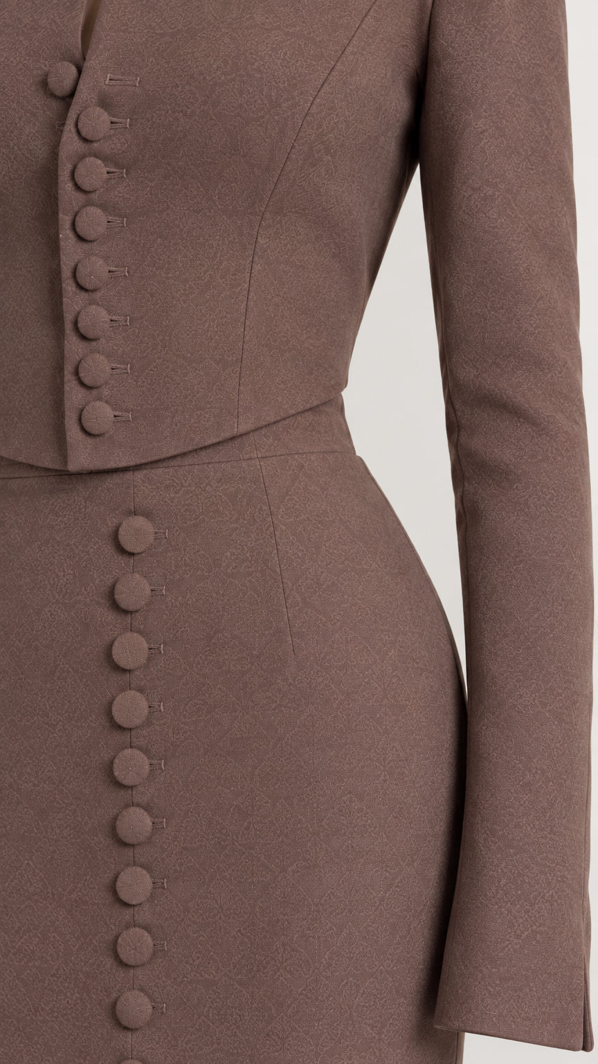 Close-up detail of covered buttons on mocha brown tailored jacket top and skirt waistline