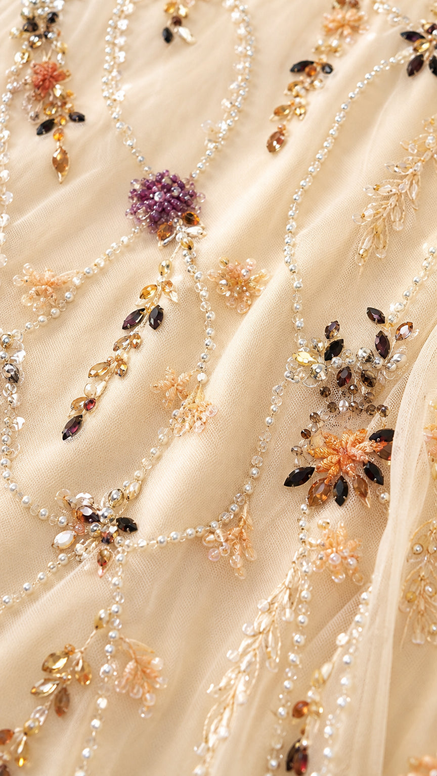 Close-up detail of delicate floral beading, sequins, and embroidery on mesh fabric