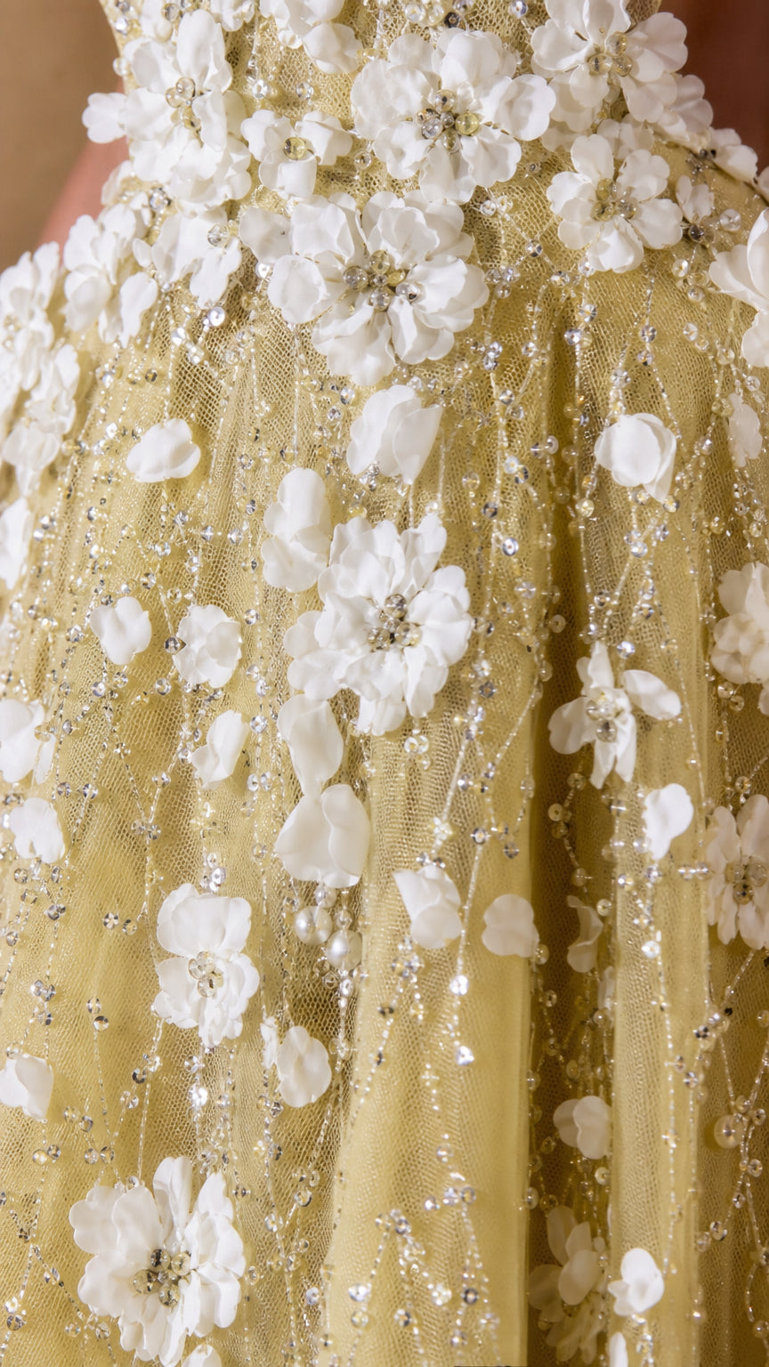 Close-up detail of 3D floral appliqués and sparkling beadwork on tulle