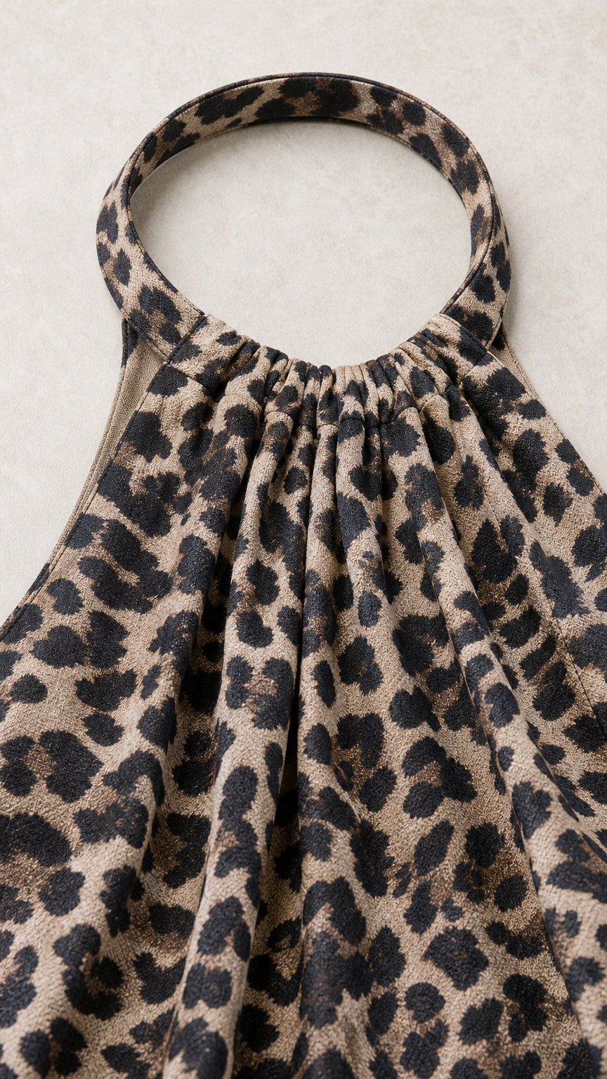 Close-up detail of gathered halter neckband on leopard print dress