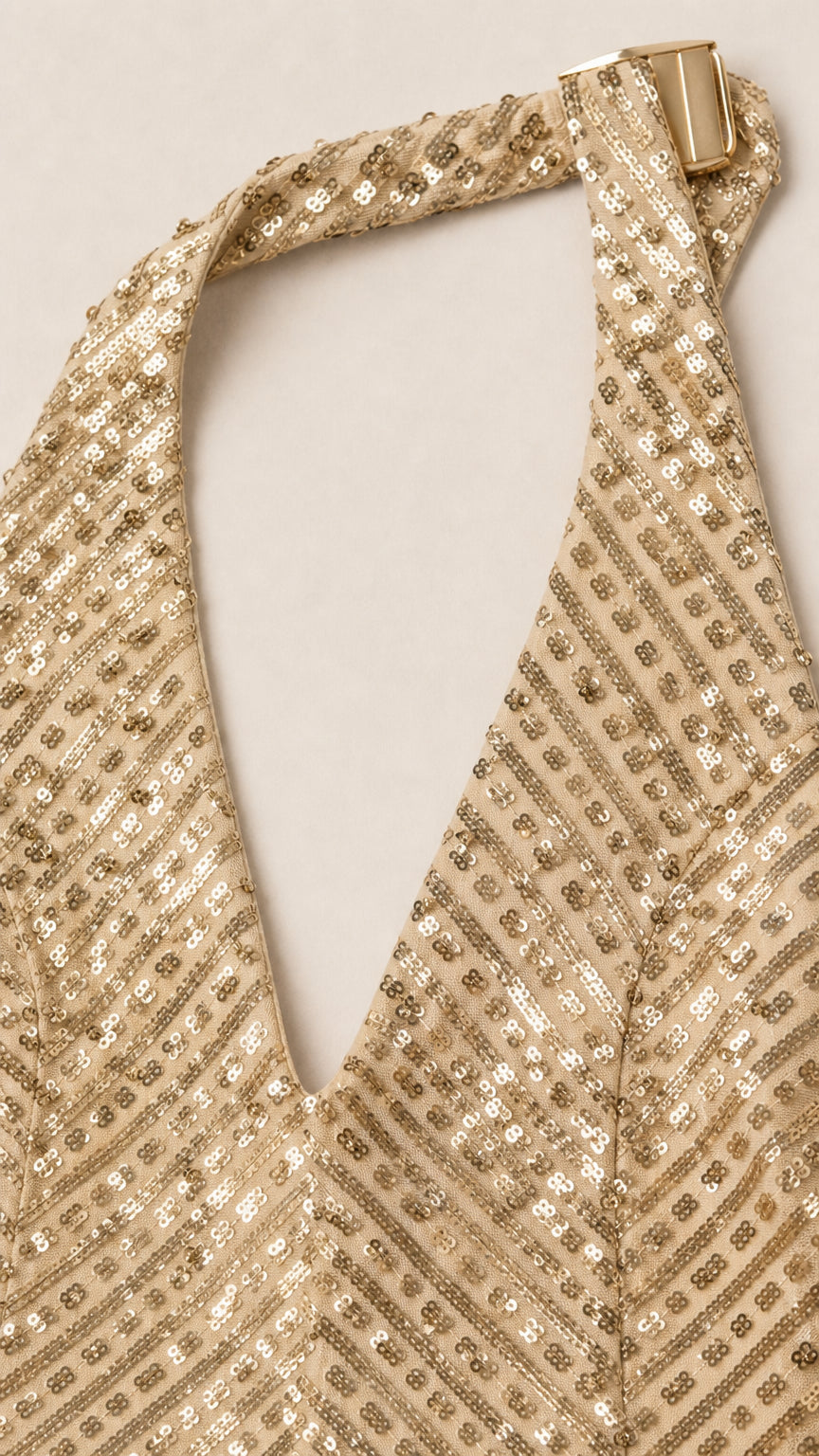 Close-up detail of halter neck closure and textured sequin pattern on neckline