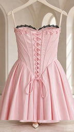 Close-up detail of pink corset bodice with lace trim and lace-up front
