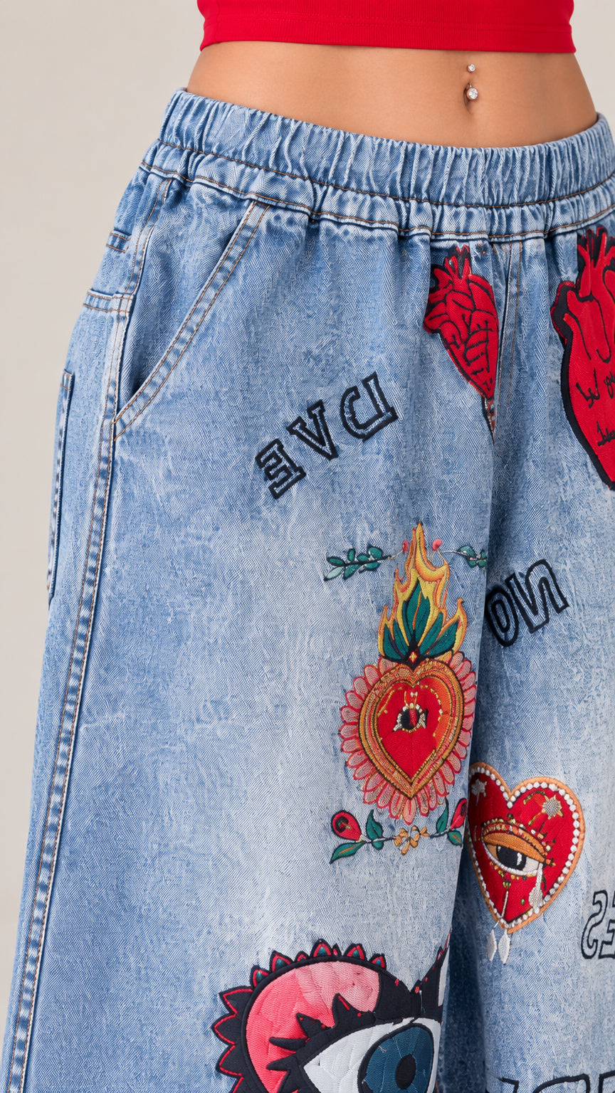 Close-up detail of elastic waistband, pocket, and colorful graphic prints on denim fabric