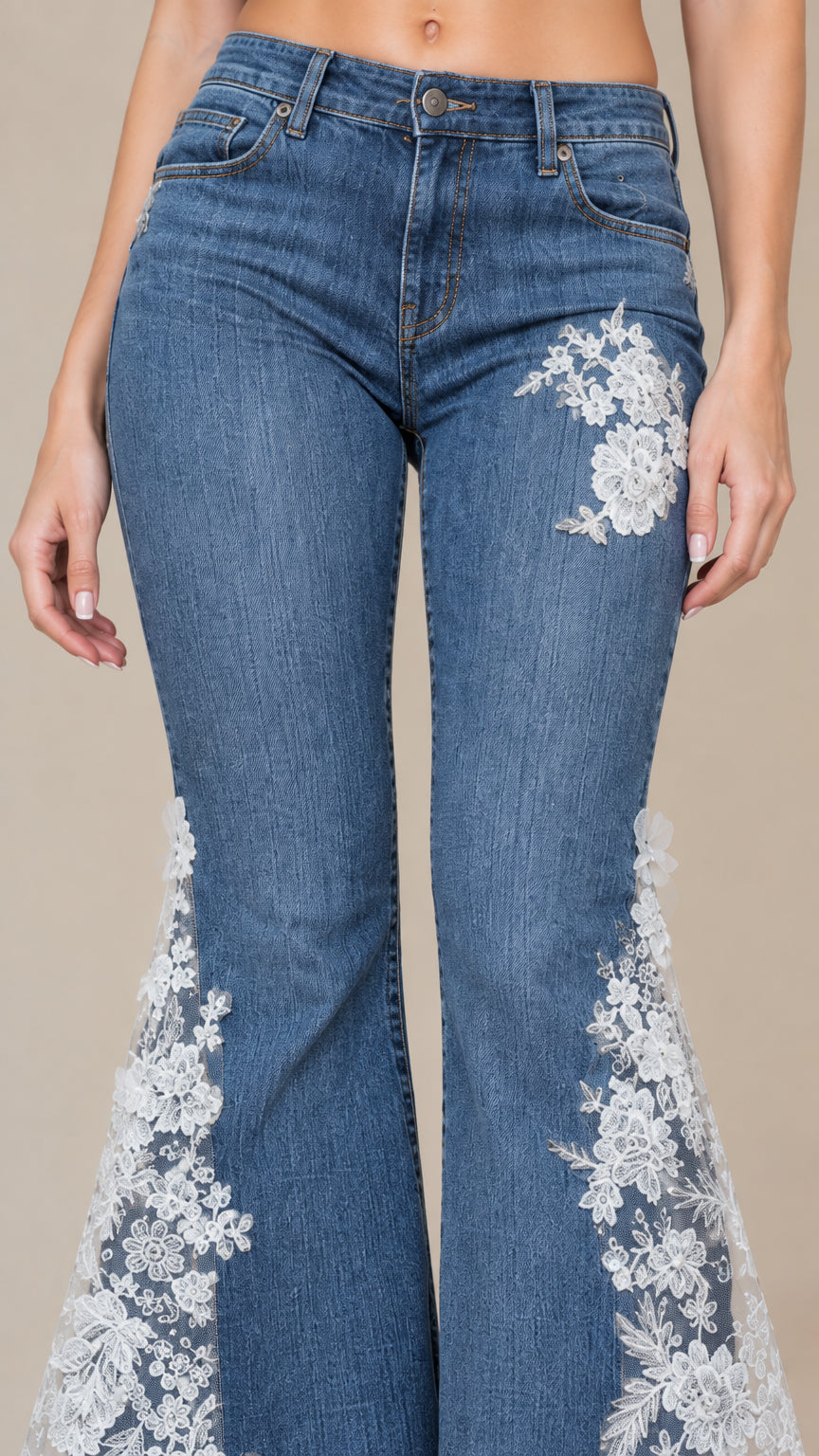 Close-up detail of thigh floral embroidery and lace godet panels on blue denim