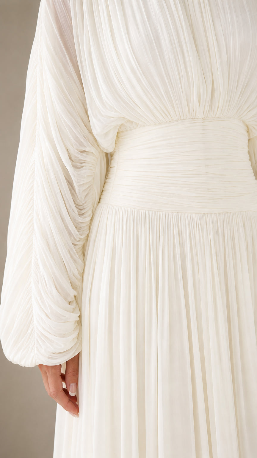 Close-up detail of pleated bodice and wide ruched waistband on white dress