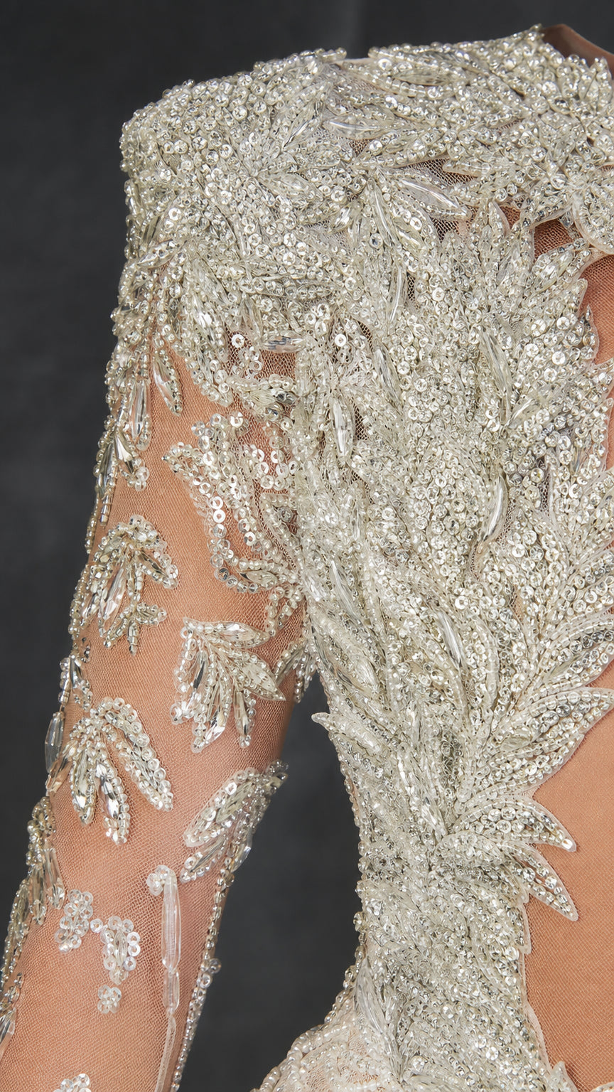 Close-up detail of intricate silver sequin and beaded embroidery on sheer mesh sleeve