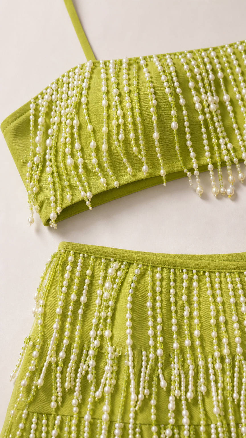 Close-up detail of lime green fabric and hanging pearl bead fringe