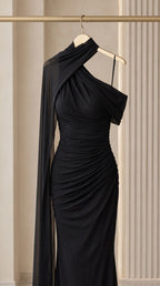 Close-up detail shot of black ruched bodycon gown on hanger highlighting neckline and drape