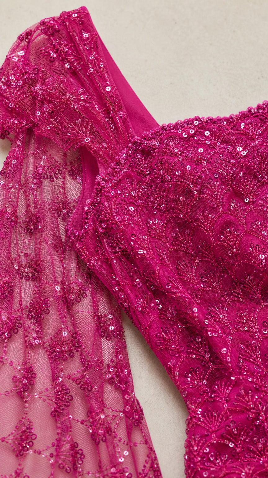 Close-up of intricate sequin embroidery and sheer cape fabric detail in Fuchsia Pink