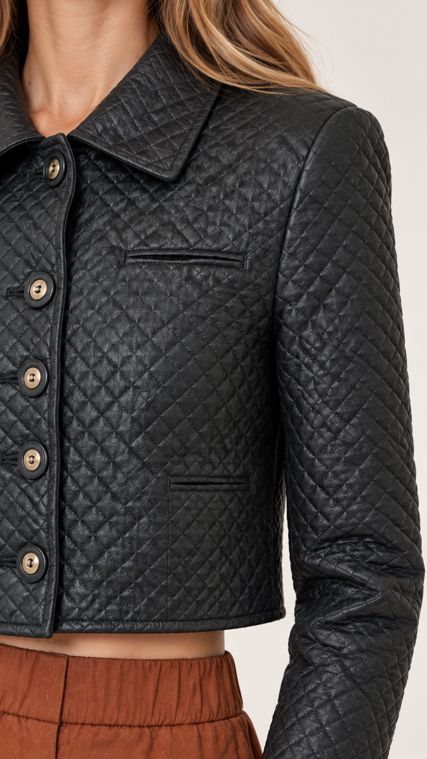 Close-up detail of textured diamond quilting, collar, and button placket on cropped jacket