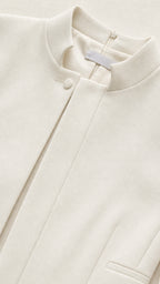 Close-up detail of stand collar and neckline on white structured romper
